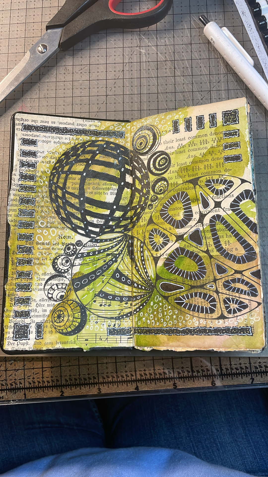 Mixed media art journal with green and black geometric patterns