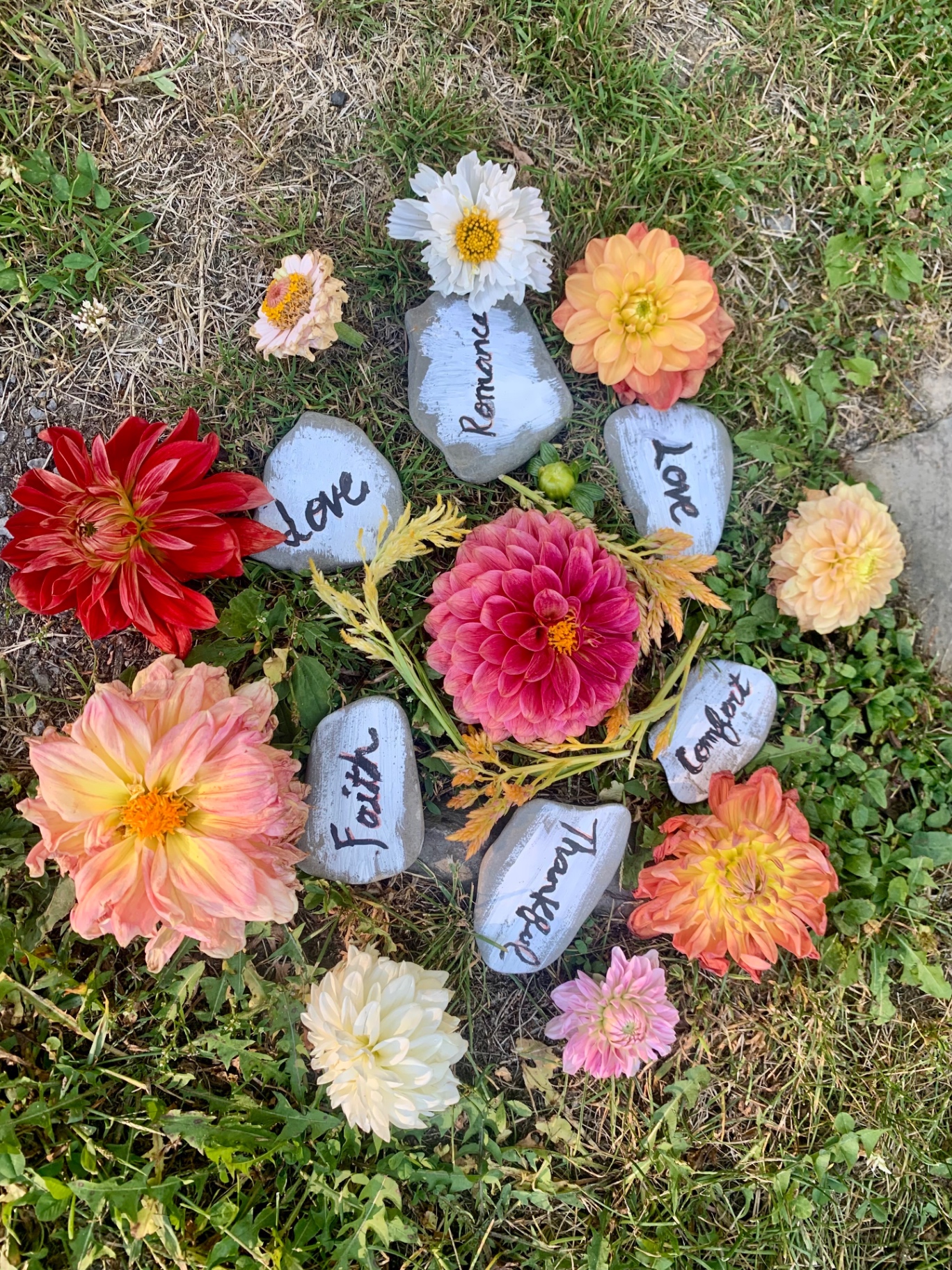 Mandala of painted rocks and fresh flowers